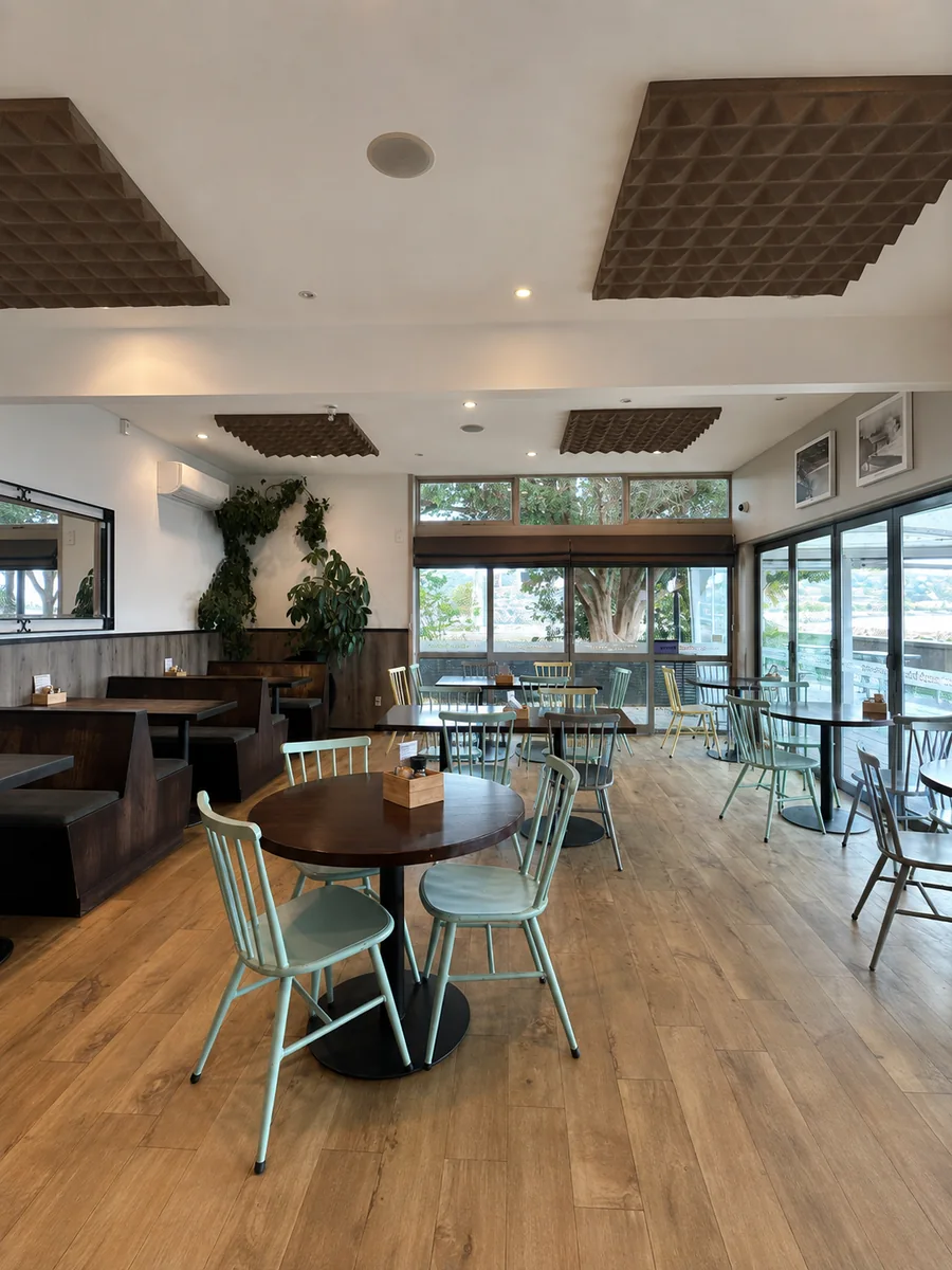 Light-filled Scarborough Fare dining room with tables beside the seafront windows
