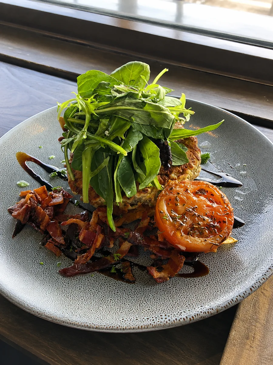 A plated savoury dish with leafy greens at Scarborough Fare